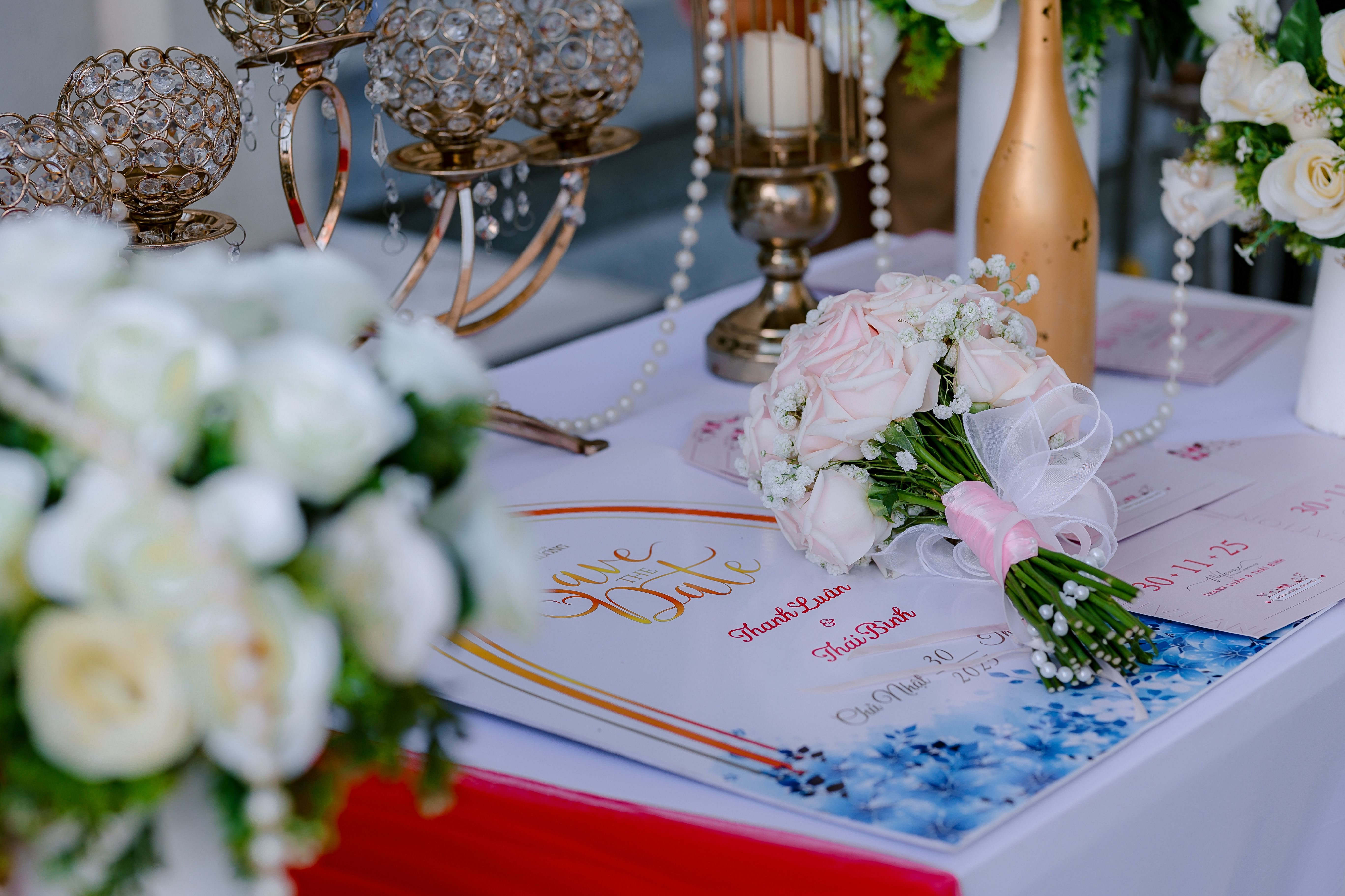 A smartphone showing a WhatsApp chat with a wedding invitation preview card and a decorated invite in the background.